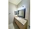 Bathroom with granite countertops, a framed mirror, and natural wood cabinetry at 5250 S Rainbow Blvd # 1131, Las Vegas, NV 89118