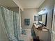 Bathroom with a tropical leaf shower curtain, a mirror, neutral walls, and modern sink at 5250 S Rainbow Blvd # 1131, Las Vegas, NV 89118