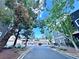 A tranquil community street with trees and green space leading to a row of garages at 5250 S Rainbow Blvd # 1131, Las Vegas, NV 89118