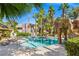 View of the community pool with rock waterfall feature, palm trees, and lounge chairs at 5250 S Rainbow Blvd # 1131, Las Vegas, NV 89118