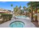 Community pool featuring hot tub, palm trees, lounge chairs, and rock waterfall features at 5250 S Rainbow Blvd # 1131, Las Vegas, NV 89118