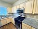 Bright kitchen featuring stainless steel appliances, granite countertops, and natural wood cabinetry at 5250 S Rainbow Blvd # 1131, Las Vegas, NV 89118