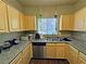 Functional kitchen with wood cabinets, granite countertops, and stainless steel appliances, maximizing space at 5250 S Rainbow Blvd # 1131, Las Vegas, NV 89118