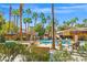 Inviting pool area with a rock waterfall feature, tiki umbrellas, and lounge chairs for relaxation at 5250 S Rainbow Blvd # 1131, Las Vegas, NV 89118