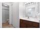 Well-lit bathroom featuring a sink vanity and adjacent tub with a glass sliding door at 5253 Westwind Rd, Las Vegas, NV 89118