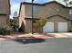A townhome with attached garages, and a manicured landscape creating curb appeal at 5253 Westwind Rd, Las Vegas, NV 89118