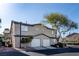 Tan two-story townhome with a two-car garage and well-maintained landscaping, creating a welcoming curb appeal at 5253 Westwind Rd, Las Vegas, NV 89118