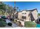 Charming exterior view featuring a private patio with mature trees and green bushes at 5253 Westwind Rd, Las Vegas, NV 89118