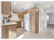 Functional kitchen with tile flooring, white appliances, and wood cabinets, providing ample storage and counter space at 5253 Westwind Rd, Las Vegas, NV 89118