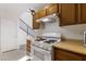 A bright kitchen featuring a gas range stove, wooden cabinets, and an adjacent staircase at 5253 Westwind Rd, Las Vegas, NV 89118