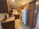 Galley kitchen features wood cabinets, tiled flooring, and full appliance package at 5253 Westwind Rd, Las Vegas, NV 89118