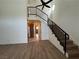 Open living space with wood floors, staircase, ceiling fan, and kitchen access at 5253 Westwind Rd, Las Vegas, NV 89118