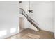Spacious living room featuring modern flooring and an open staircase with sleek black railings and vaulted ceiling at 5253 Westwind Rd, Las Vegas, NV 89118