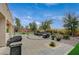 Spacious backyard with BBQ, outdoor seating, lush greenery, and manicured landscaping at 549 Via Balizan Ave, Las Vegas, NV 89123