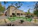 A spacious backyard showcasing meticulous landscaping including rocks, artificial turf and a cozy two-story house at 549 Via Balizan Ave, Las Vegas, NV 89123