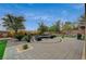 Backyard with stone patio, outdoor seating, BBQ, lush greenery, and manicured landscaping at 549 Via Balizan Ave, Las Vegas, NV 89123