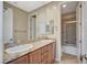 Bathroom featuring double sinks with granite countertops and a shower-tub combo behind a sliding door at 549 Via Balizan Ave, Las Vegas, NV 89123