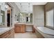 Beautiful bathroom featuring double sinks, a bathtub with tile surround and a large, frameless mirror at 549 Via Balizan Ave, Las Vegas, NV 89123