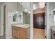 Charming bathroom with double sinks, tile flooring, granite countertops and a custom walk-in closet at 549 Via Balizan Ave, Las Vegas, NV 89123