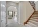 Hallway with a staircase, tiled flooring, and an arched doorway to a living room at 549 Via Balizan Ave, Las Vegas, NV 89123