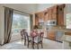 This bright dining area features custom wood cabinets, a tile backsplash, and stainless appliances at 549 Via Balizan Ave, Las Vegas, NV 89123