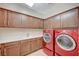 Functional laundry room with sink, countertop space, and red washer and dryer at 549 Via Balizan Ave, Las Vegas, NV 89123