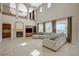 Bright and airy living room with a fireplace, large windows, tile floors, and comfortable sectional sofa at 549 Via Balizan Ave, Las Vegas, NV 89123