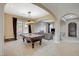 Elegant living room featuring a pool table, comfortable seating, and an open floor plan at 549 Via Balizan Ave, Las Vegas, NV 89123
