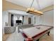 Spacious living room features a pool table, modern chandelier, comfortable seating, and stylish decor at 549 Via Balizan Ave, Las Vegas, NV 89123