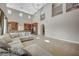 Bright living room boasts soaring ceilings, tile flooring, and a comfortable sectional couch at 549 Via Balizan Ave, Las Vegas, NV 89123