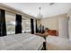 Spacious main bedroom featuring large windows, neutral carpet, modern light fixture and tan walls at 549 Via Balizan Ave, Las Vegas, NV 89123