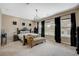 Main bedroom with a large window, carpeted floors, and a comfortable chaise lounge at 549 Via Balizan Ave, Las Vegas, NV 89123