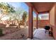 A cozy backyard featuring a covered patio, desert landscaping, and a charcoal grill at 5518 Ovando Way, Las Vegas, NV 89122