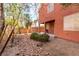 Exterior view of a backyard with desert landscaping, bushes, and covered patio at 5518 Ovando Way, Las Vegas, NV 89122