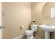 Traditional half bath with toilet, pedestal sink, mirror, and decorative flowers at 5518 Ovando Way, Las Vegas, NV 89122