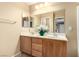 Bathroom featuring a double sink vanity, large mirror, and decorative floral arrangement at 5518 Ovando Way, Las Vegas, NV 89122