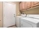 Functional laundry room with modern washer and dryer units and overhead storage at 5518 Ovando Way, Las Vegas, NV 89122