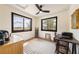 Bright bedroom with two windows offering scenic views, complemented by neutral tones and a ceiling fan at 5570 N Nopah Vista Ave, Pahrump, NV 89060