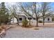 Exterior of home featuring rock landscaping and a mature tree-lined yard at 5570 N Nopah Vista Ave, Pahrump, NV 89060