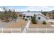 Exterior front view of the home featuring xeriscaping, decorative gate, and white perimeter fence at 5570 N Nopah Vista Ave, Pahrump, NV 89060