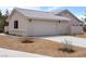 Attached garage with a wide driveway and desert landscaping offers convenient parking at 5570 N Nopah Vista Ave, Pahrump, NV 89060