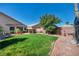 Large backyard with lush green grass, desert landscaping, and beautiful hardscape at 5578 River Highlands Pl, Las Vegas, NV 89122