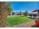 Spacious backyard features a well-maintained lawn, shed, desert landscaping, and a glimpse of the refreshing pool beyond at 5578 River Highlands Pl, Las Vegas, NV 89122