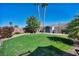 Lush backyard with vibrant green lawn, desert landscaping, and ample space for outdoor activities and enjoyment at 5578 River Highlands Pl, Las Vegas, NV 89122