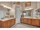 Bathroom featuring double vanity sinks, wood cabinets, and decorative lighting at 5578 River Highlands Pl, Las Vegas, NV 89122
