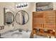 Bathroom featuring a round mirror, storage shelves, and a bathtub with sliding glass doors at 5578 River Highlands Pl, Las Vegas, NV 89122