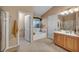 Well-lit bathroom features separate vanities, soaking tub, and tiled floors, offering a comfortable and luxurious space at 5578 River Highlands Pl, Las Vegas, NV 89122