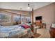 Bedroom featuring a four poster bed, seating area, and view of the outdoors at 5578 River Highlands Pl, Las Vegas, NV 89122