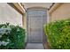 Charming courtyard featuring a decorative metal gate surrounded by lush greenery, enhancing privacy and curb appeal at 5578 River Highlands Pl, Las Vegas, NV 89122