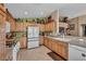 Well-lit kitchen features wooden cabinets, tile floors, and modern white appliances at 5578 River Highlands Pl, Las Vegas, NV 89122